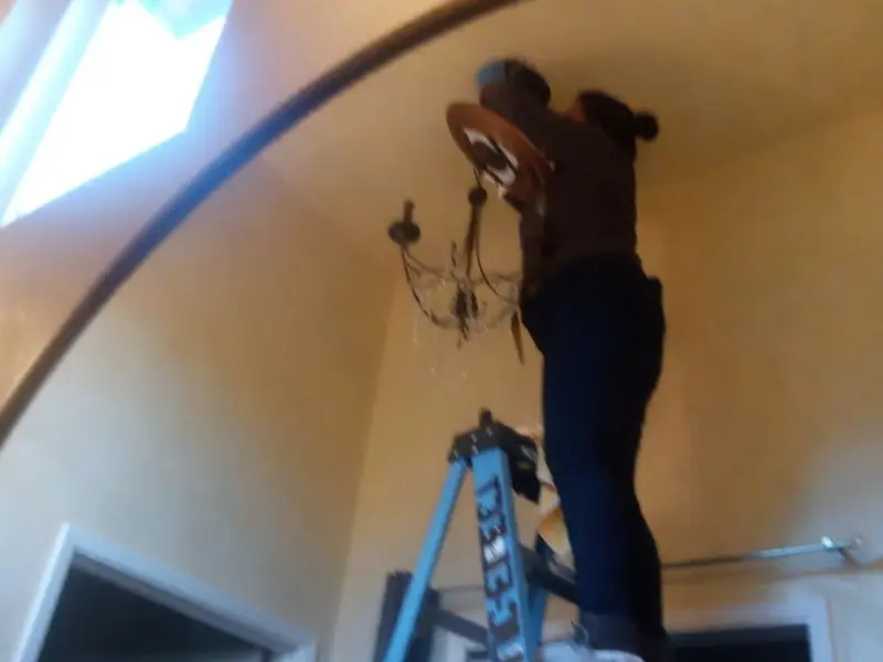 Electrician installing a chandelier in a Antelope residence
